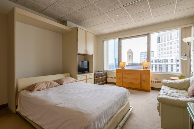 bedroom featuring light colored carpet, a paneled ceiling, multiple windows, and radiator