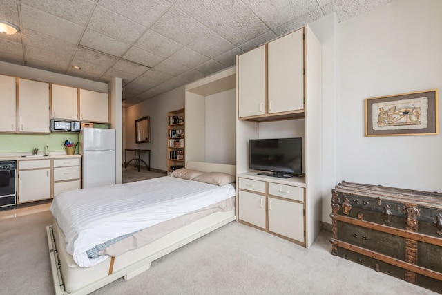 bedroom with sink, light colored carpet, and white fridge