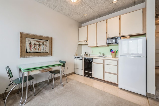 kitchen featuring white cabinets, light colored carpet, black appliances, and sink