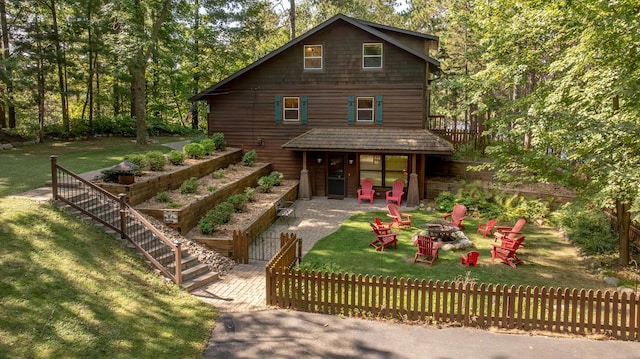 8607 Nottingham Rd, Lake Shore, MN 56468 - view of front of house featuring fence, an outdoor fire pit, a front lawn, and a patio