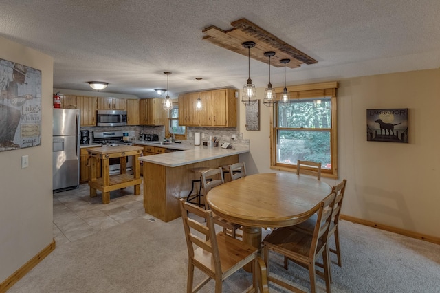 dining space featuring light carpet, a textured ceiling, and sink