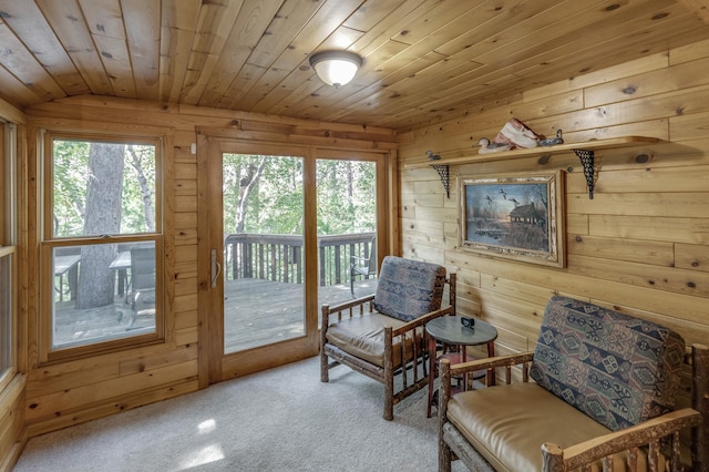 sitting room with carpet floors, wood ceiling, wood walls, and vaulted ceiling