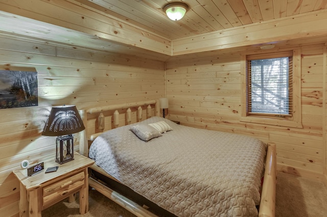 carpeted bedroom with wooden ceiling and wood walls