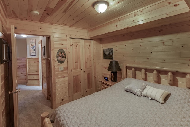 carpeted bedroom with wood ceiling and wood walls