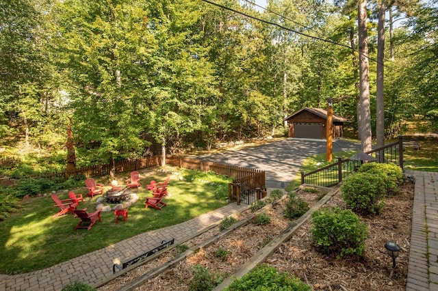 view of yard with an outdoor structure, a garage, and a fire pit