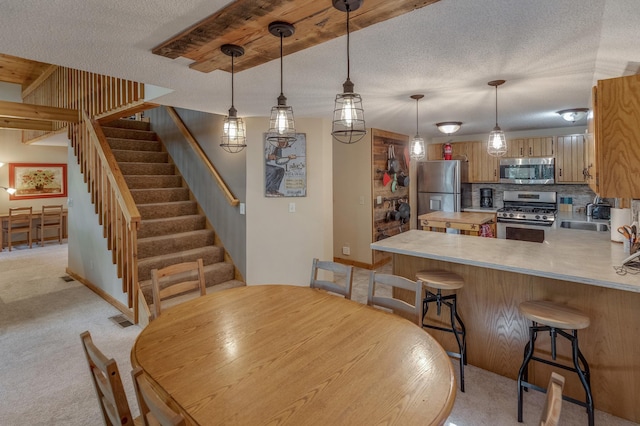 carpeted dining room featuring sink and a textured ceiling