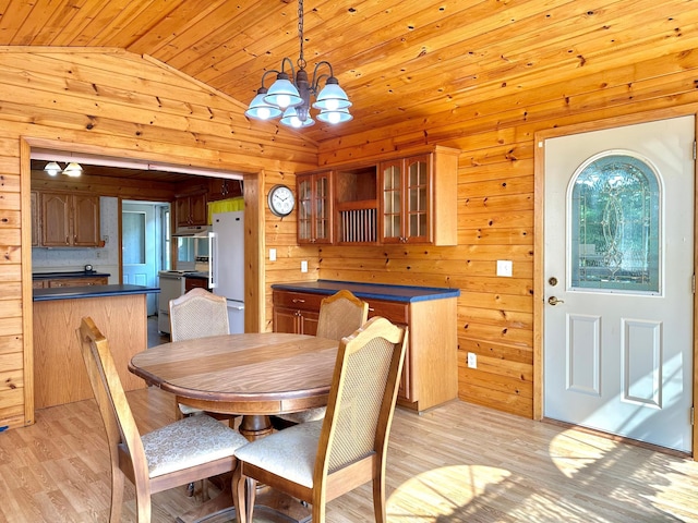39534 92nd Ave, Onamia, MN 56359 - dining area featuring vaulted ceiling, wood ceiling, light wood finished floors, a chandelier, and wooden walls