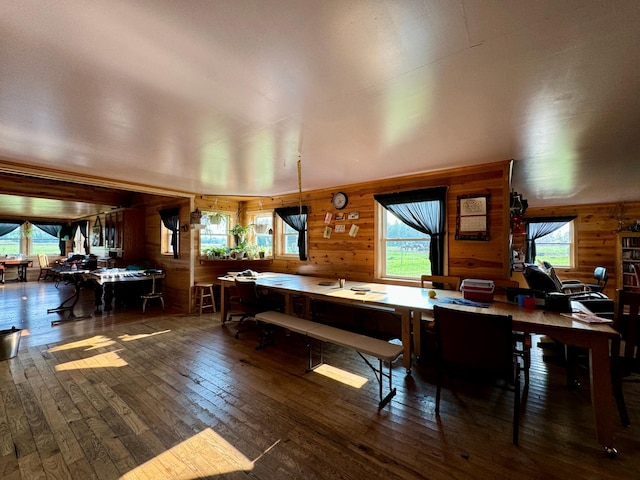 dining area featuring wood walls and dark wood-type flooring