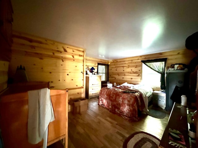 bedroom with wood walls and hardwood / wood-style flooring