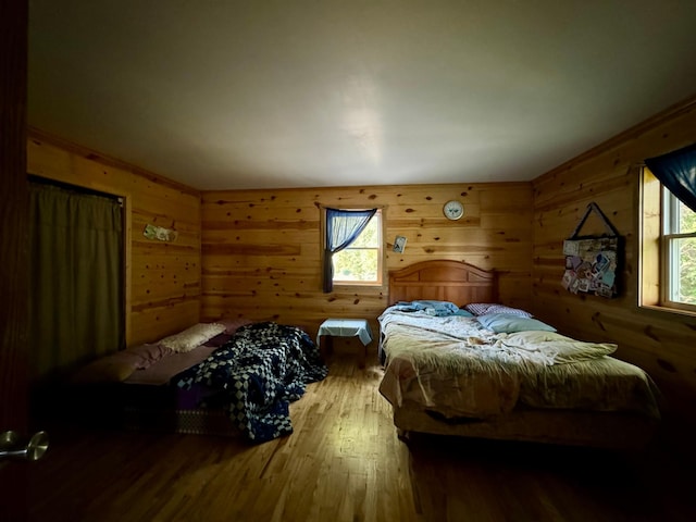 bedroom featuring wood walls and hardwood / wood-style flooring