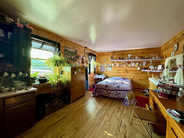 bedroom featuring wooden walls and light hardwood / wood-style flooring