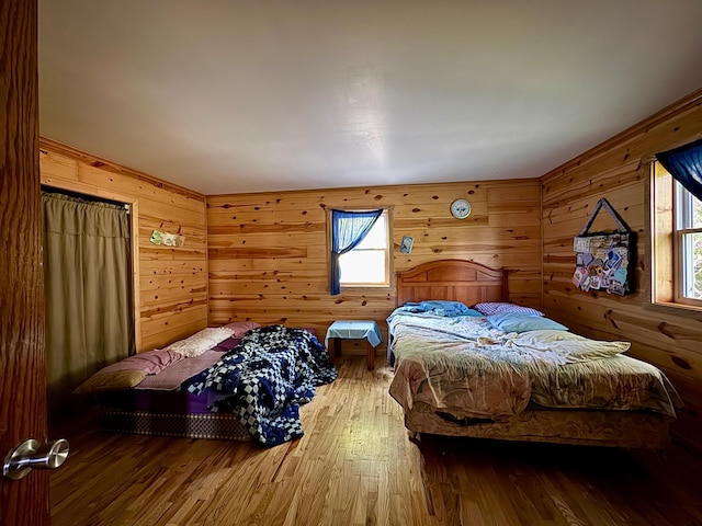 bedroom featuring wood walls and hardwood / wood-style floors