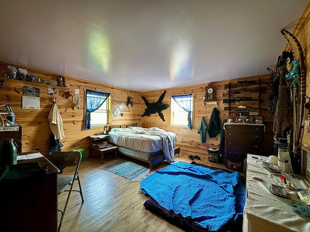 bedroom with wooden walls and hardwood / wood-style floors