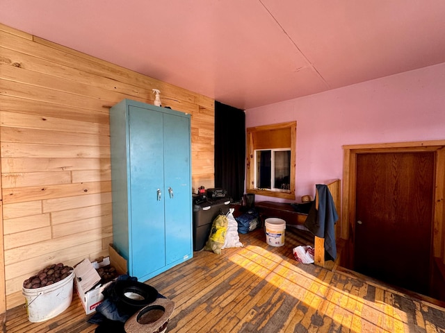 bedroom with wood-type flooring and wood walls