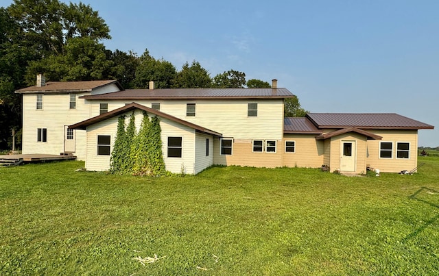 rear view of property featuring a lawn