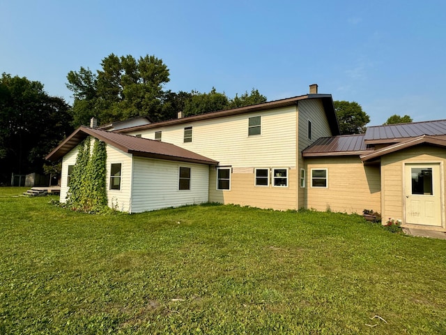 rear view of property with a yard