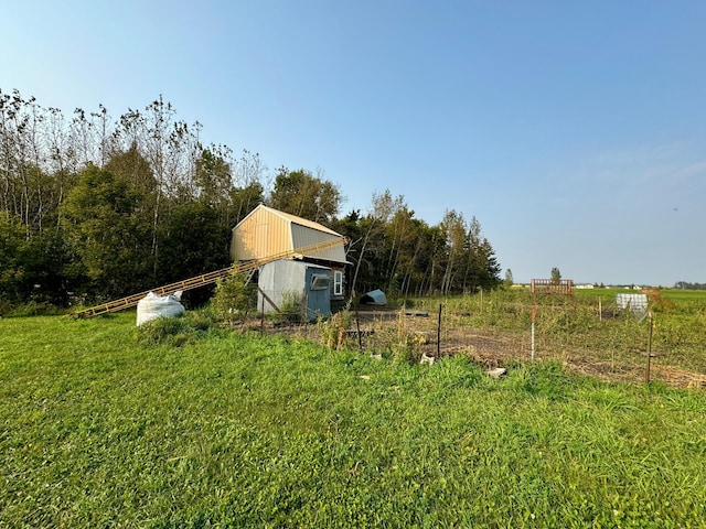 view of yard featuring a rural view and a storage shed