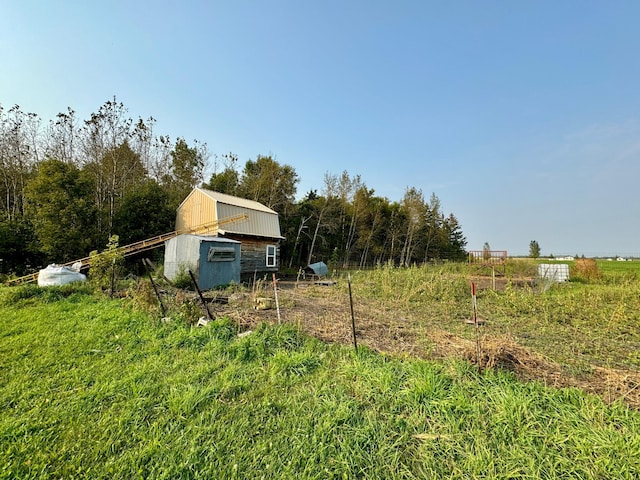 view of yard with an outdoor structure and a rural view