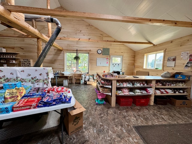 bedroom with wood walls, a wood stove, and lofted ceiling with beams