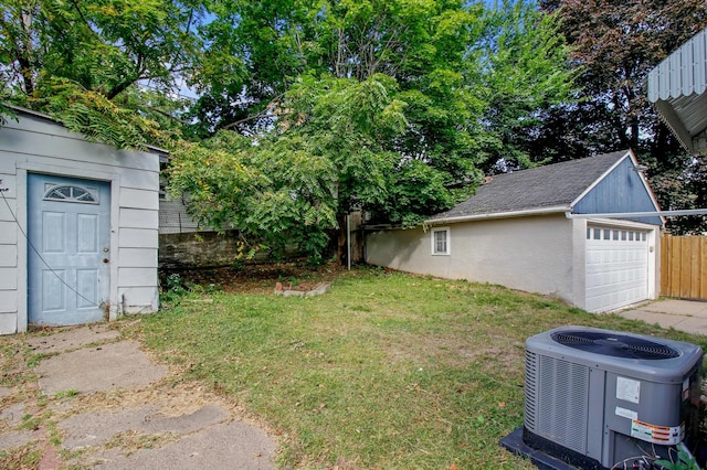 view of yard featuring an outdoor structure, a garage, and central AC