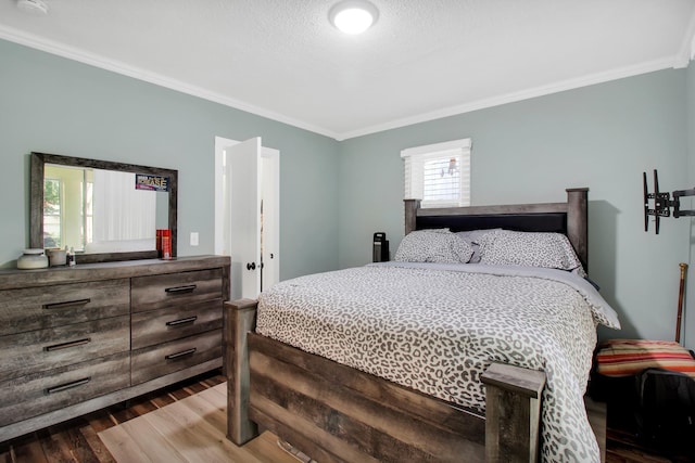 bedroom featuring a textured ceiling, crown molding, and dark wood-type flooring