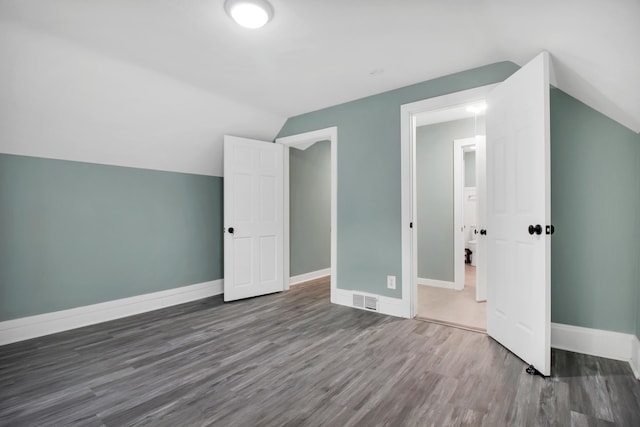 additional living space with vaulted ceiling and dark hardwood / wood-style floors