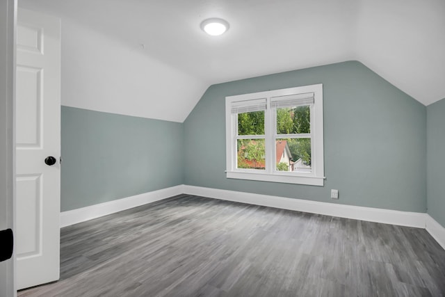bonus room featuring baseboards, wood finished floors, and lofted ceiling