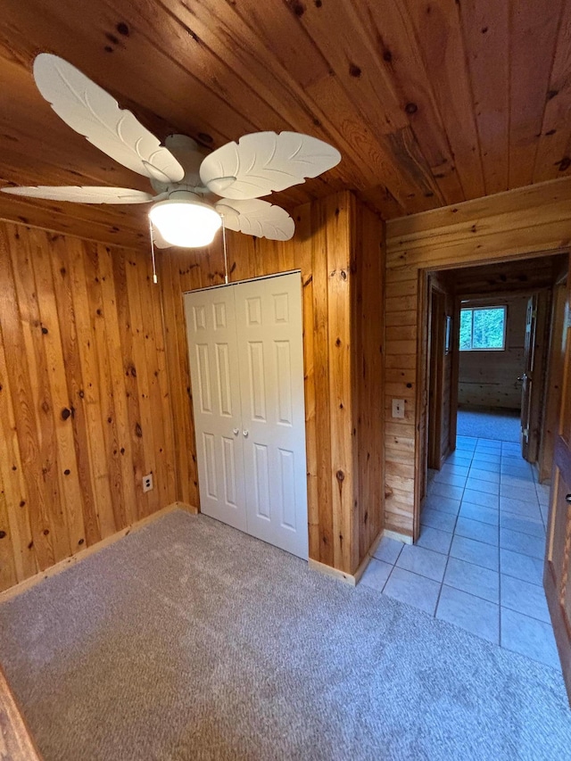 corridor featuring light tile patterned floors, wooden walls, and wooden ceiling