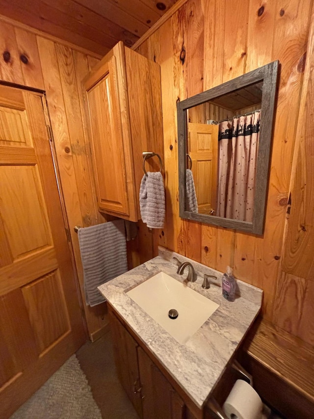 bathroom with wood walls and vanity