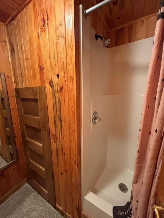 bathroom with curtained shower and wooden walls