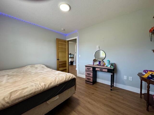 bedroom featuring dark hardwood / wood-style floors and a textured ceiling