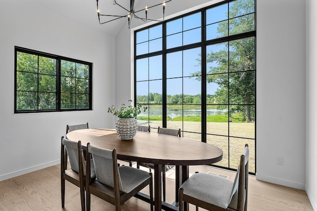 21236 Crescent Curv, Credit River Twp, MN 55044 - dining area with a chandelier, a water view, light wood finished floors, and baseboards