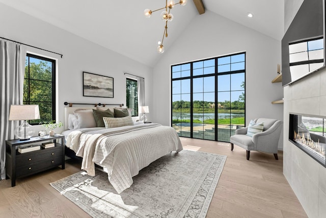21236 Crescent Curv, Credit River Twp, MN 55044 - bedroom with high vaulted ceiling, a glass covered fireplace, a water view, light wood finished floors, and beam ceiling