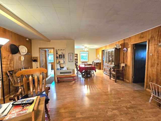 dining room featuring wood walls, ceiling fan, and hardwood / wood-style flooring