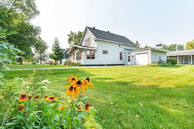 rear view of property featuring a lawn and a garage