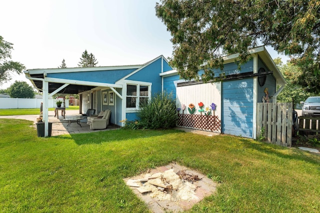 back of property with a lawn and a patio