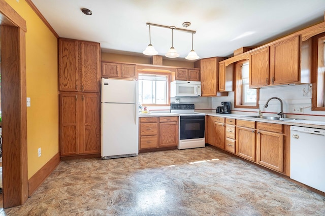 kitchen with pendant lighting, white appliances, a healthy amount of sunlight, and sink