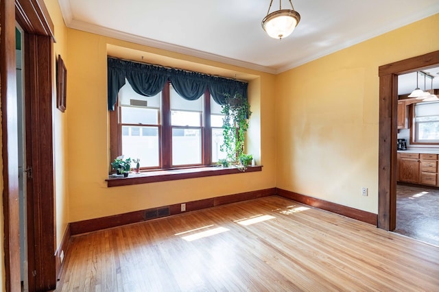 empty room featuring wood-type flooring and crown molding