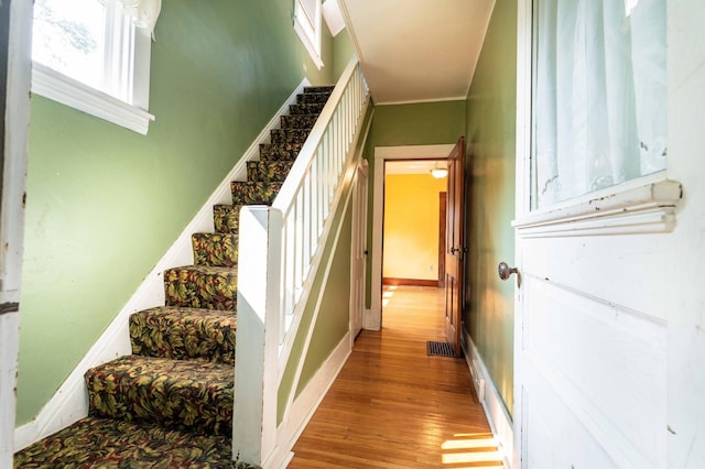 stairway featuring hardwood / wood-style flooring and crown molding