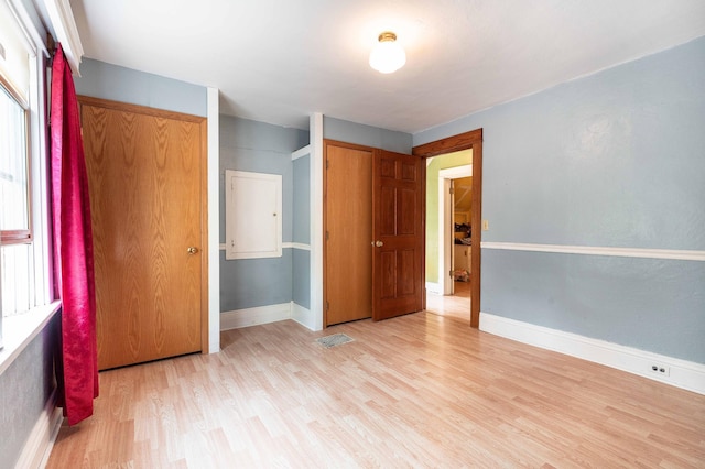 unfurnished bedroom featuring light hardwood / wood-style flooring and multiple windows