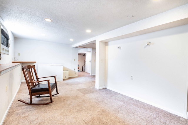 living area featuring a textured ceiling and light colored carpet