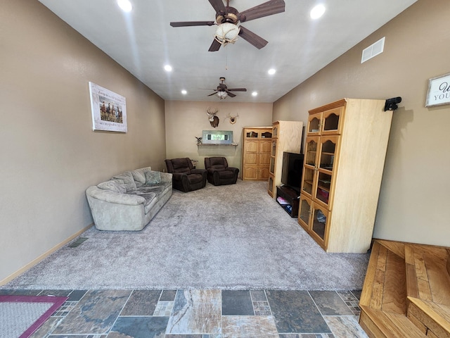 living area with ceiling fan and dark colored carpet