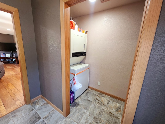 clothes washing area with stacked washer / dryer and light hardwood / wood-style floors