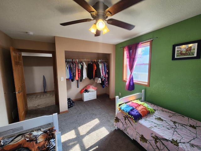 carpeted bedroom with a textured ceiling, ceiling fan, and a closet