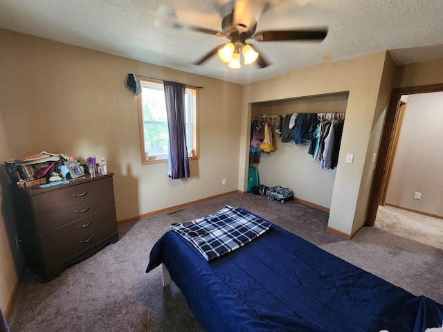 carpeted bedroom with a closet, ceiling fan, and a textured ceiling