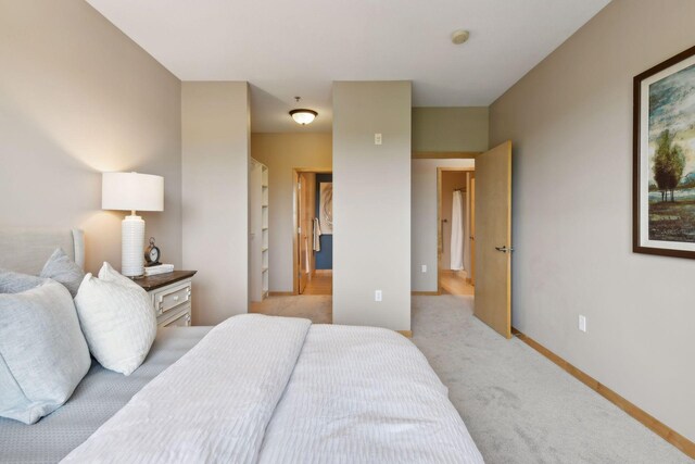 bedroom featuring light carpet and baseboards