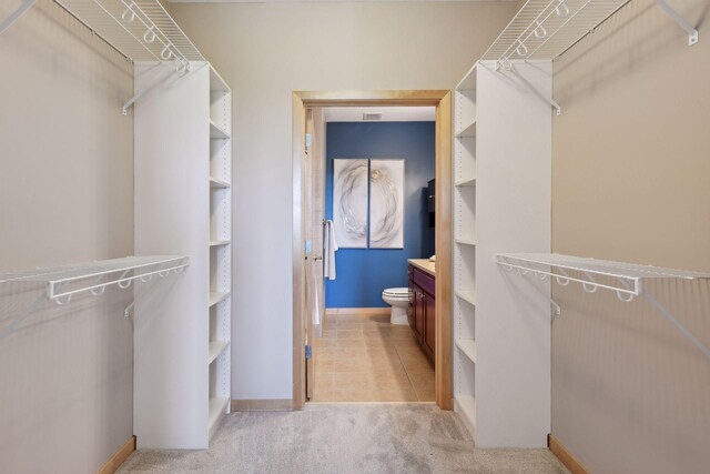 spacious closet featuring light carpet and light tile patterned floors