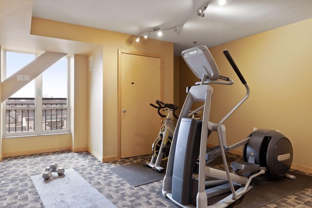 workout area featuring track lighting, carpet flooring, and baseboards