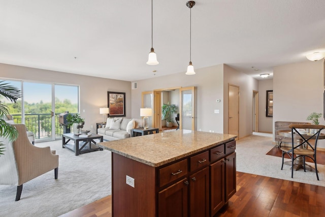 kitchen featuring hanging light fixtures, open floor plan, dark wood finished floors, and a kitchen island