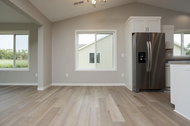 kitchen featuring lofted ceiling, light hardwood / wood-style flooring, stainless steel fridge with ice dispenser, and white cabinets